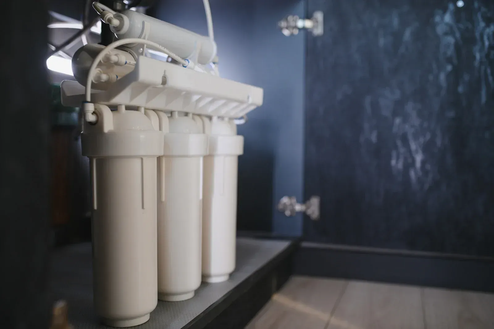 A man is kneeling down in front of a manhole cover.