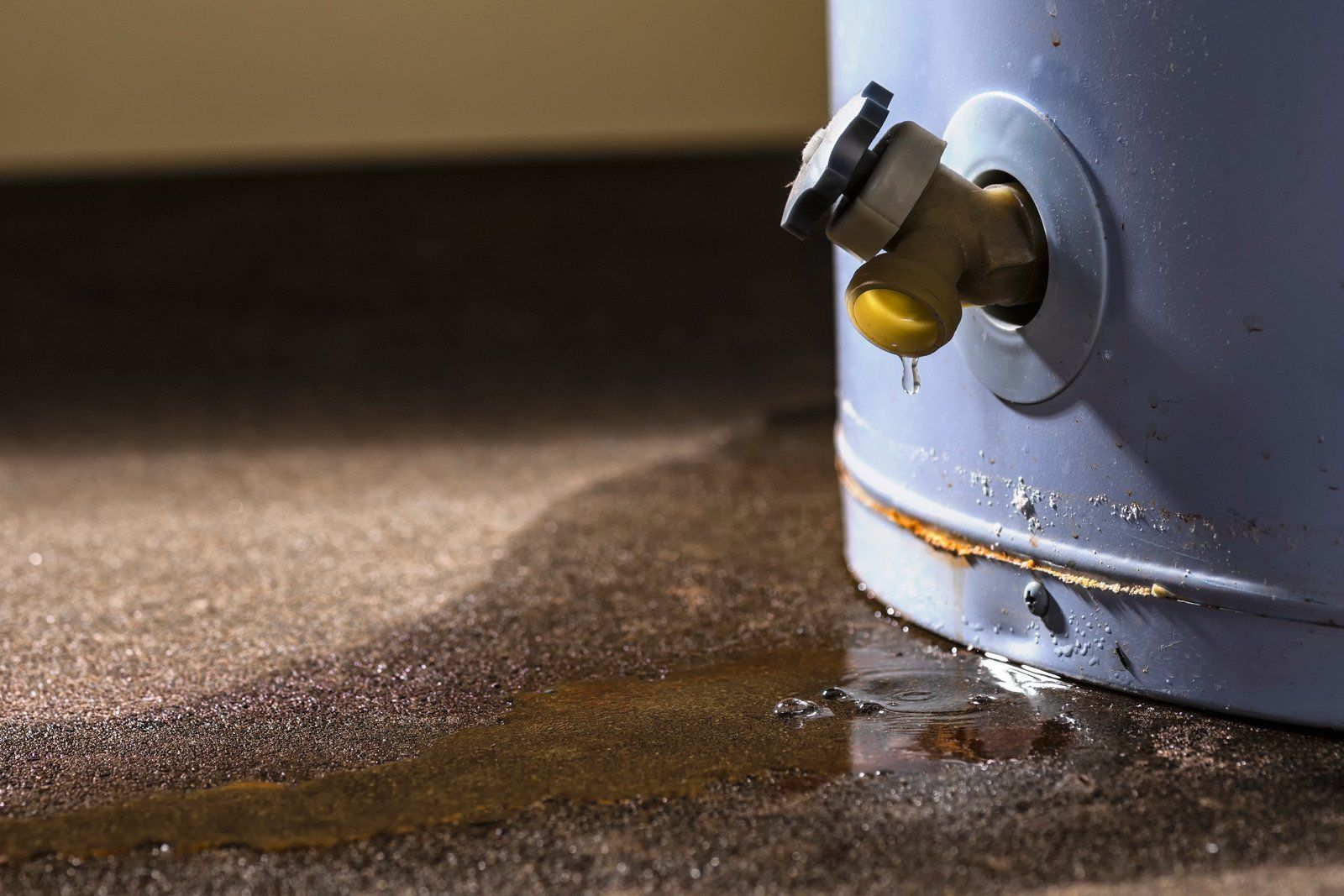 A water heater is leaking water on the floor.