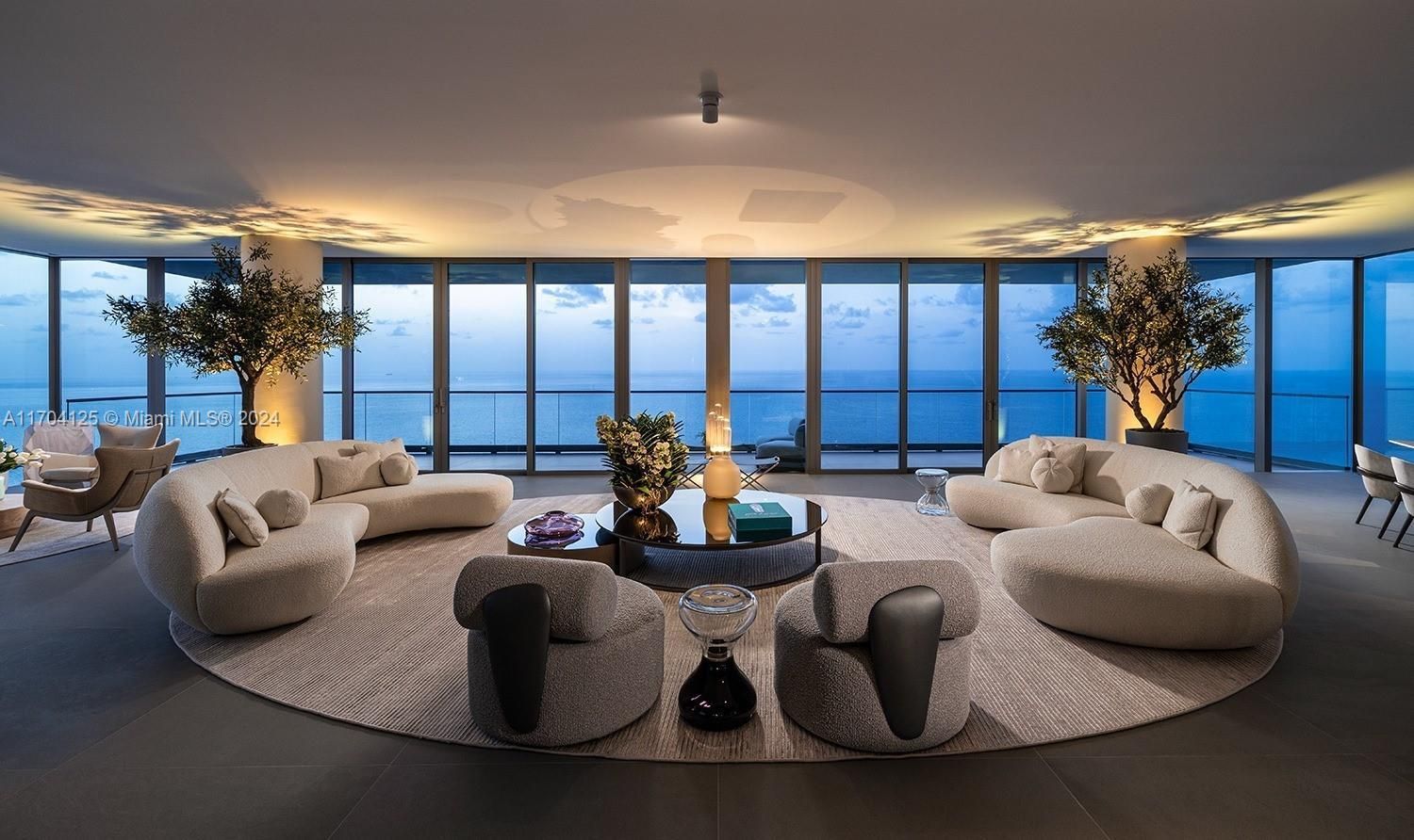 Spacious modern living room with ocean views, curved sofas, and neutral tones.