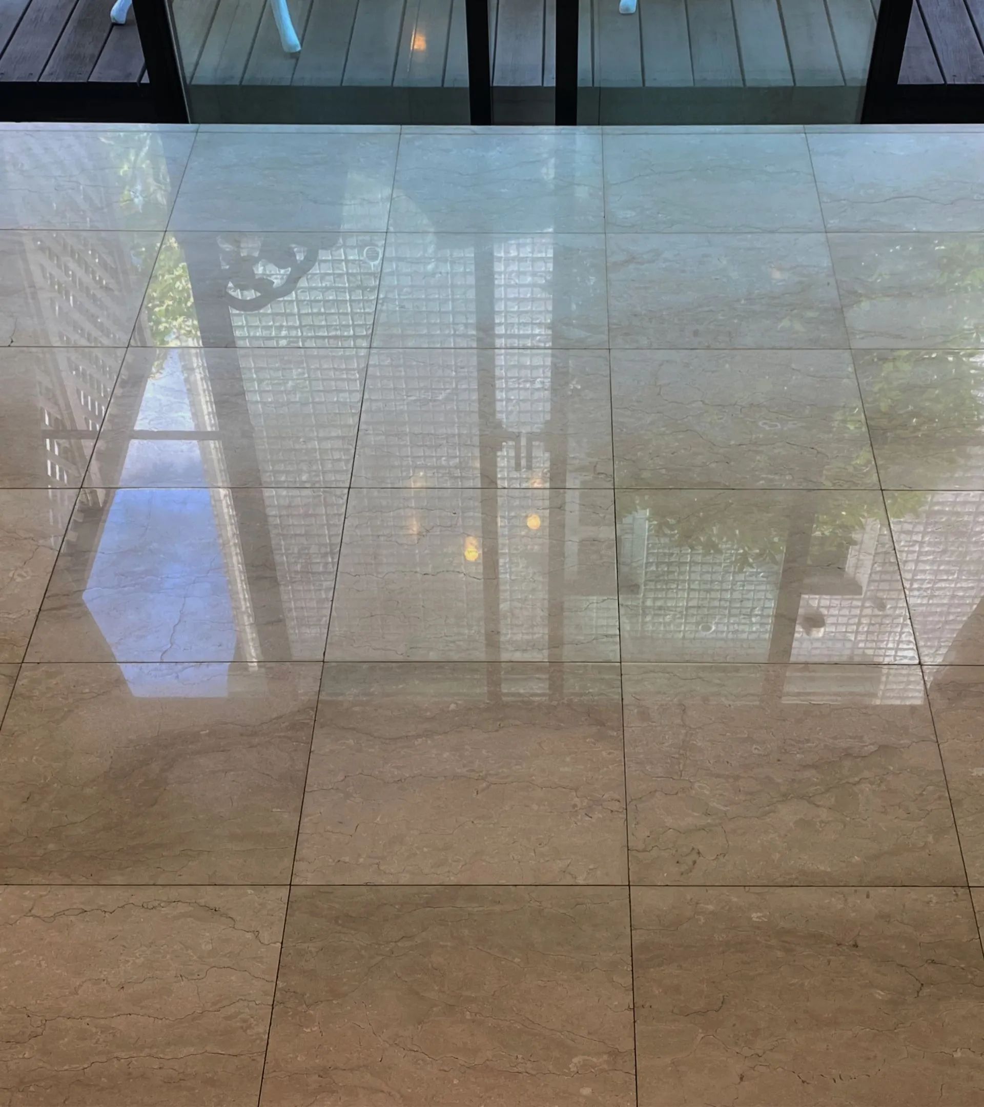 A tiled floor with a reflection of a window