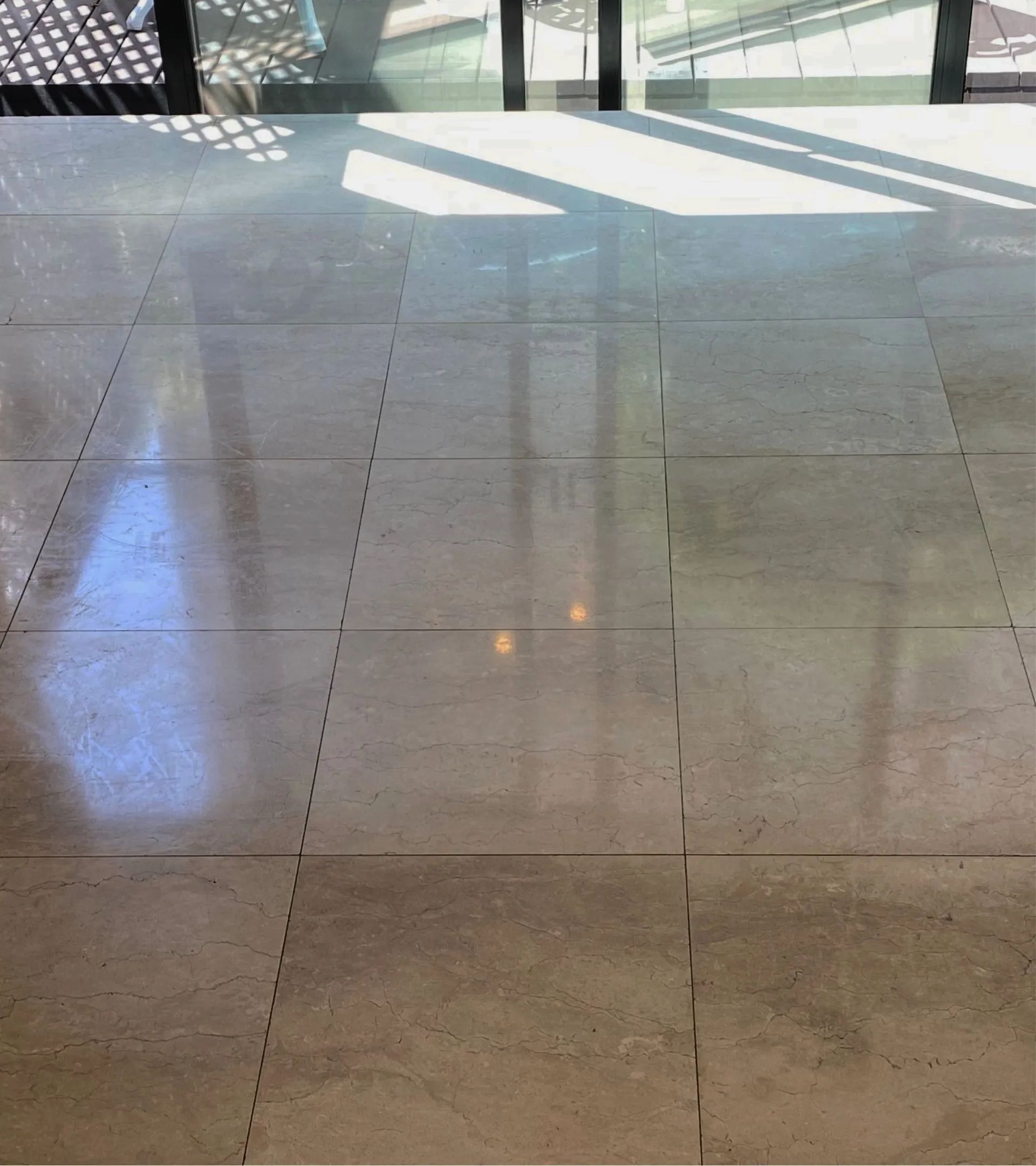 A shiny tiled floor with a window in the background