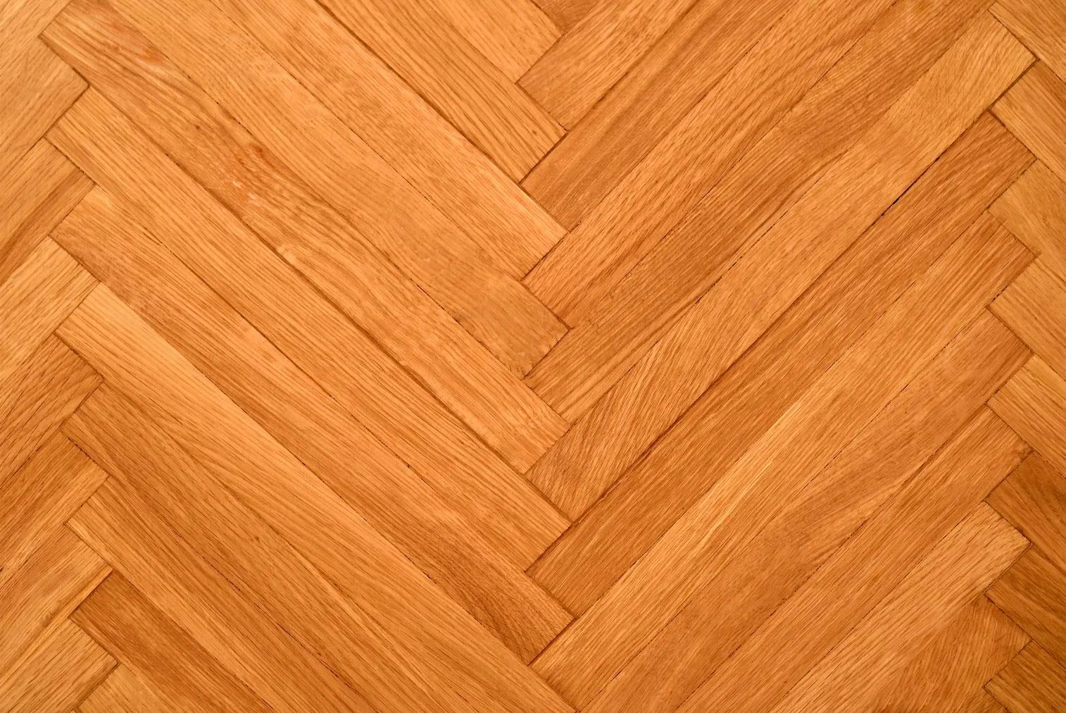 A close up of a wooden floor with a herringbone pattern.
