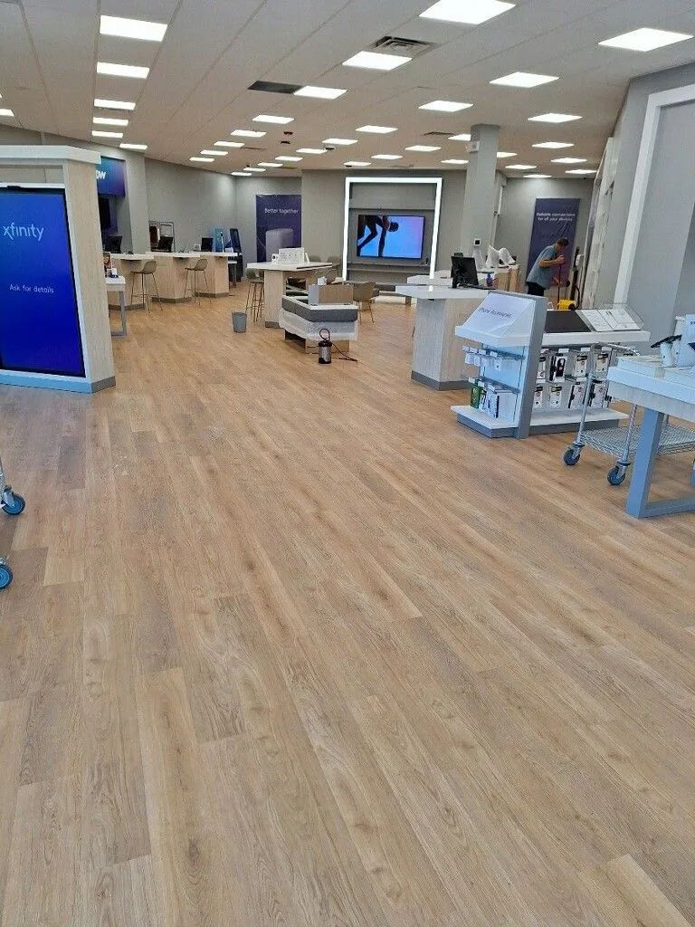 A large room with wooden floors and a lot of tables and chairs.