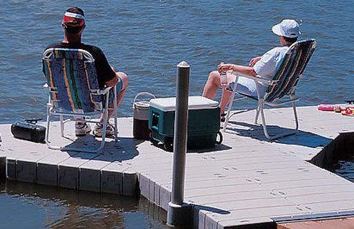 An image of two people relaxing on a 1000 series low profile dock on a sunny day.