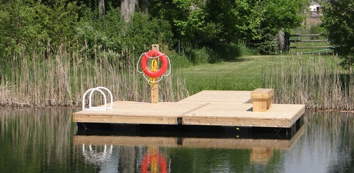 A custom wood floating dock featuring a ladder and built-in bench