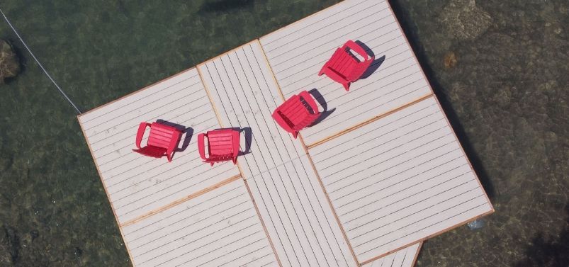 Aerial view of a dock with adirondack chairs