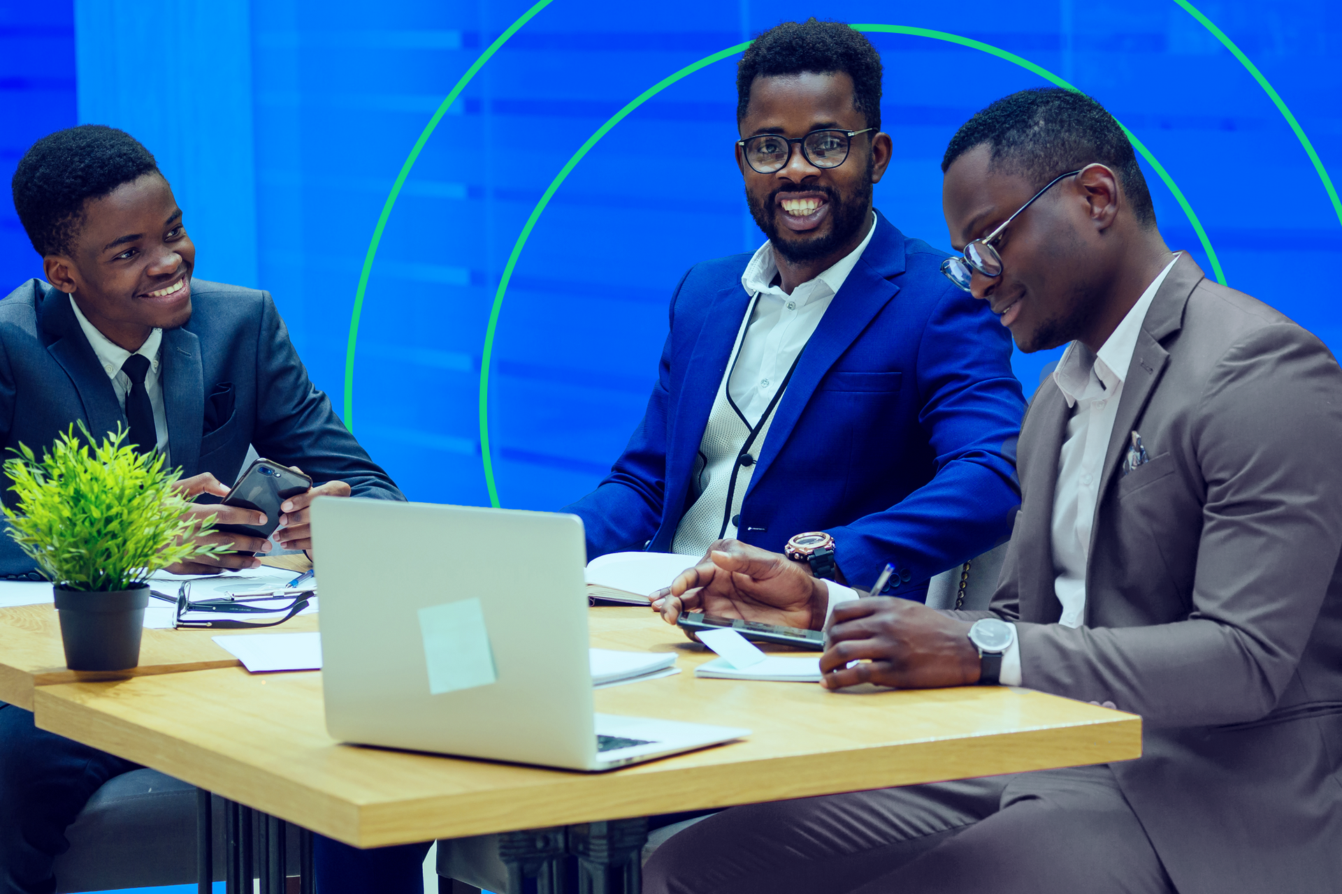 Three people sitting around a table having a meeting.