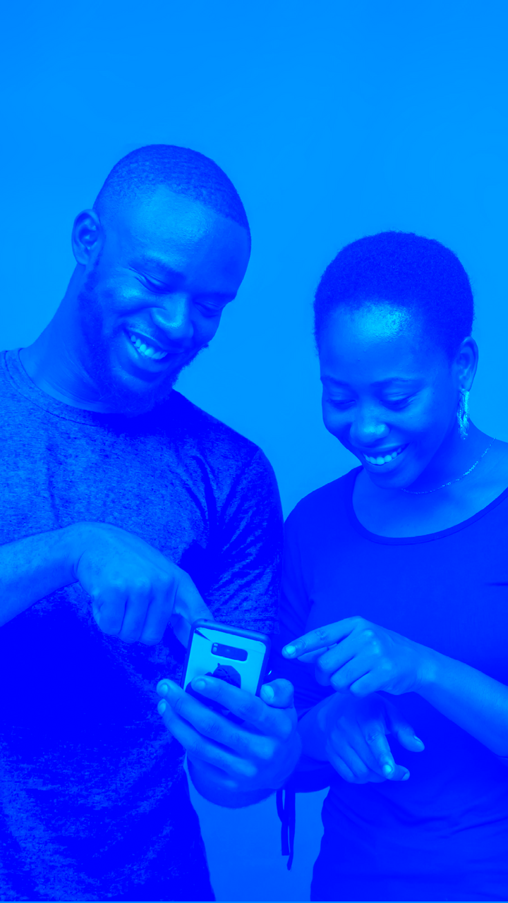 A man and a woman are looking at a cell phone together.