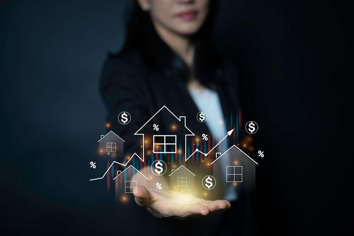 Two men shaking hands at a table, one in a suit and the other in a blue shirt, coffee cup present.