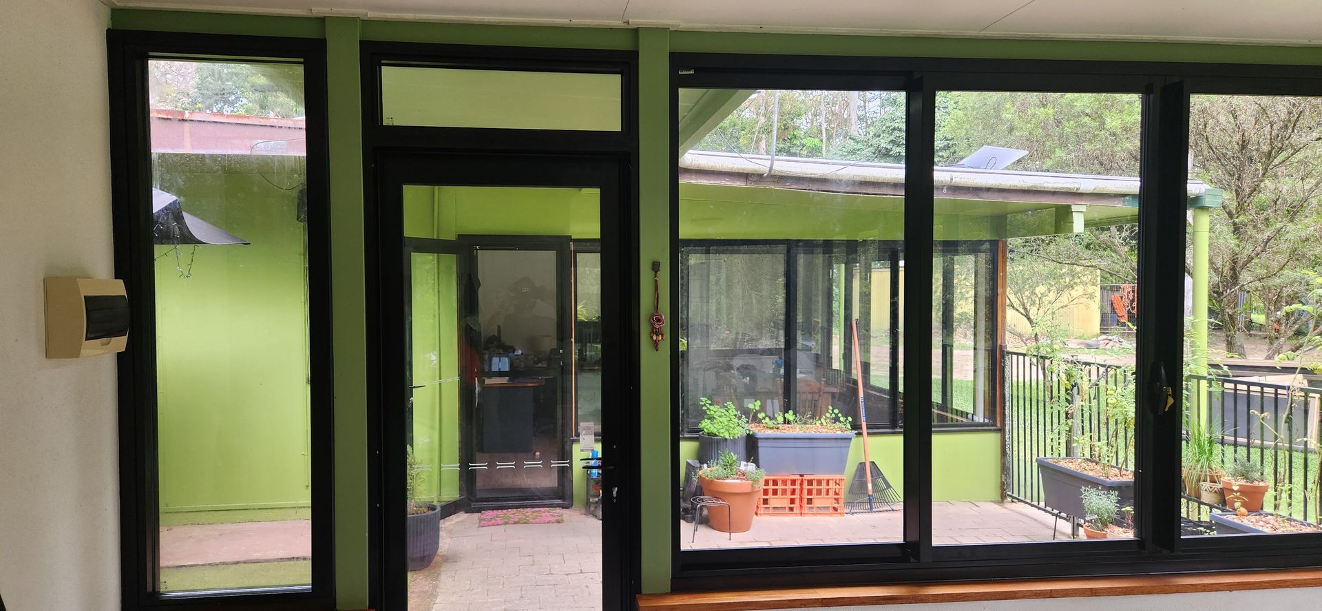 View through windows of a green house and patio with plants - Advancetech Glass & Glazing in Wulguru, QLD 