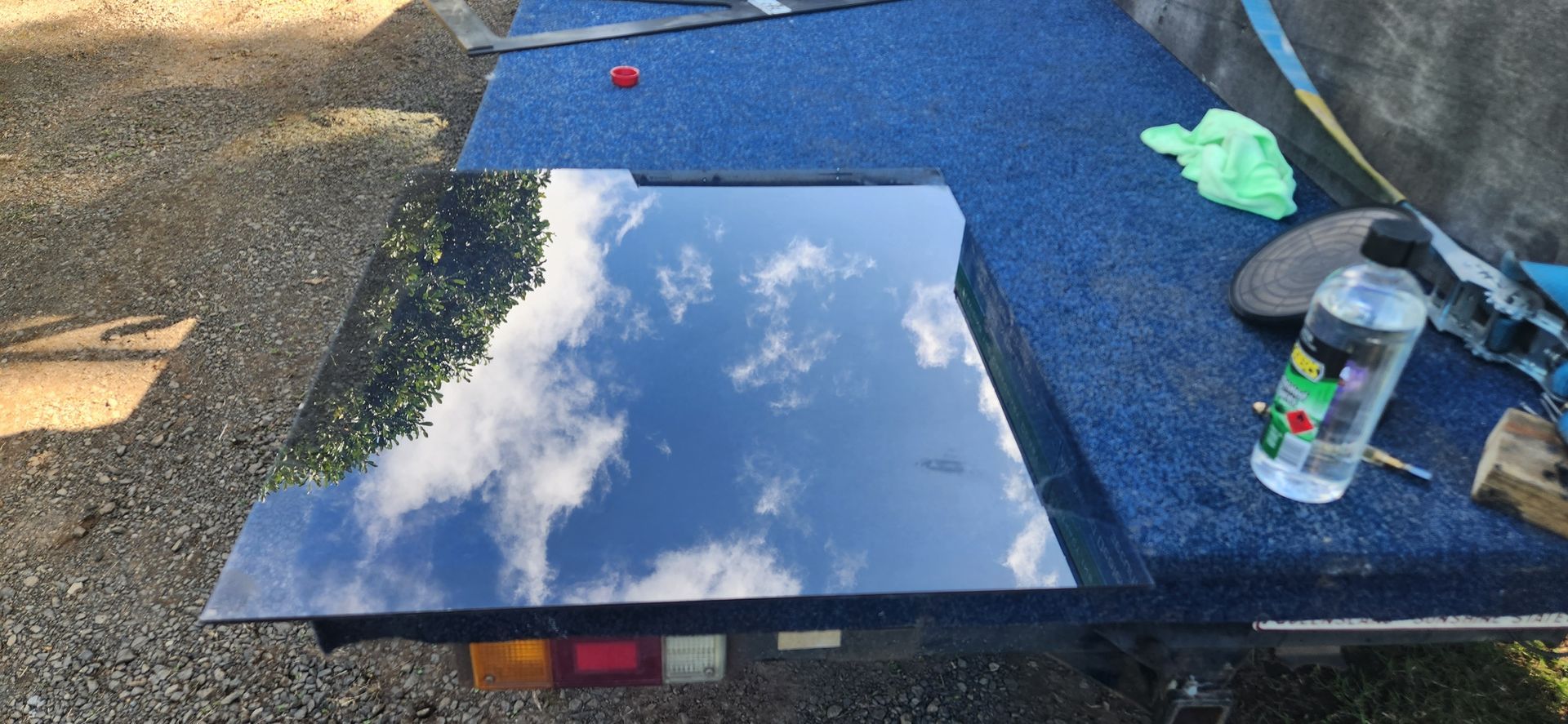 View through a screen door of a vehicle parked on a gravel driveway under a blue sky - Advancetech Glass & Glazing in Wulguru, QLD  