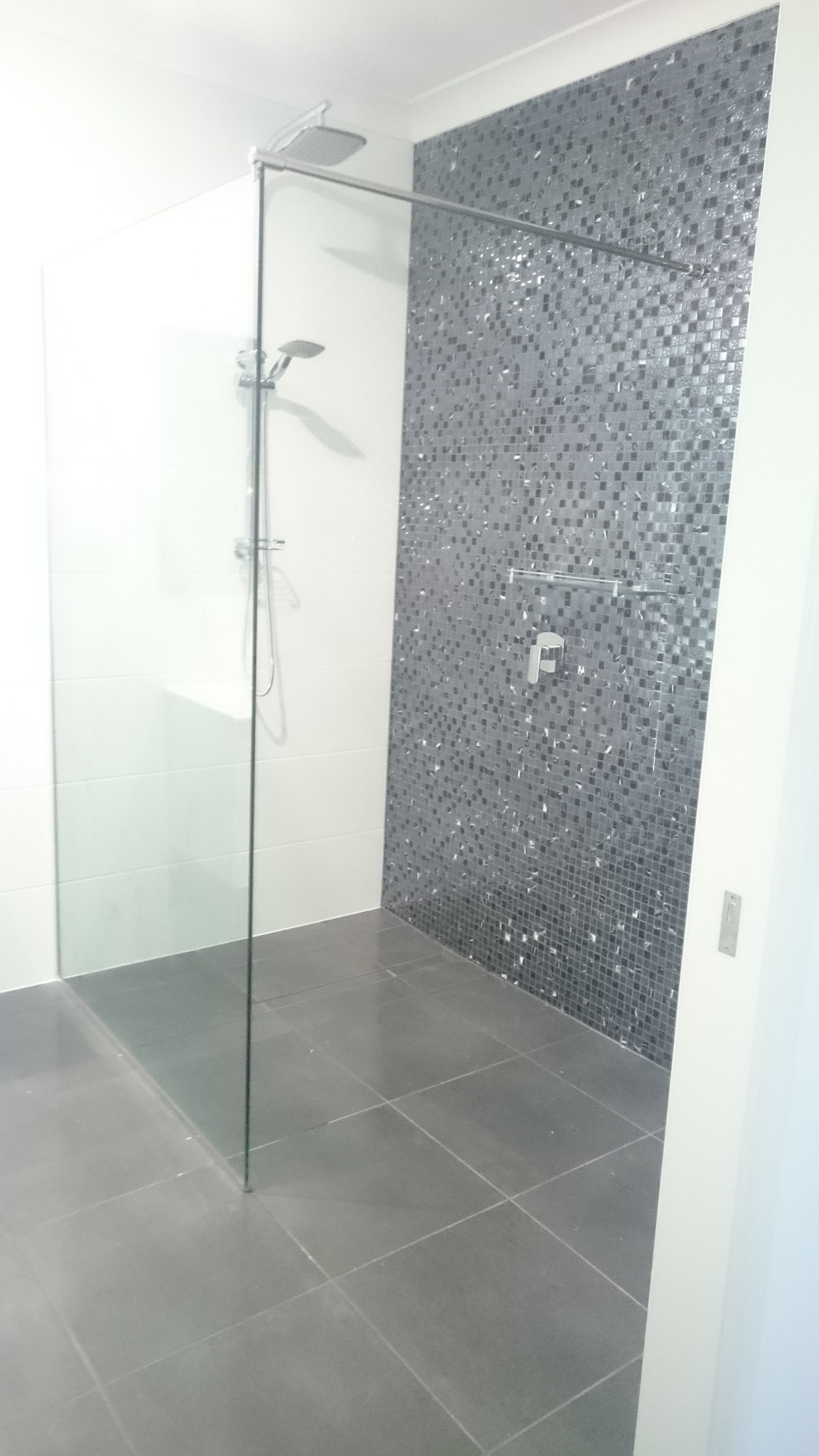 Bathroom with a frosted glass shower, white toilet and vanity, and overhead rain shower head — Advancetech Glass & Glazing in Wulguru, QLD 
