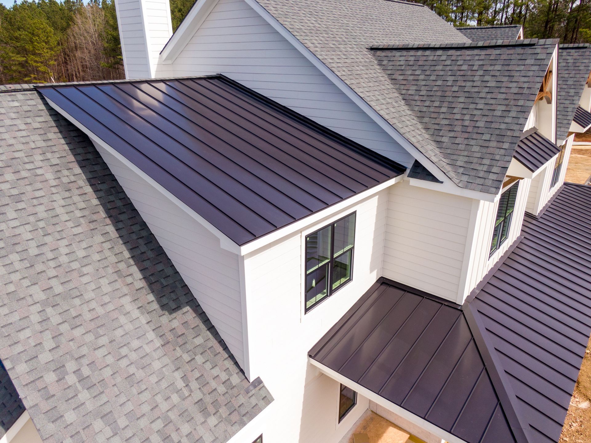 Custom roof featuring a asphalt shingles and metal seams