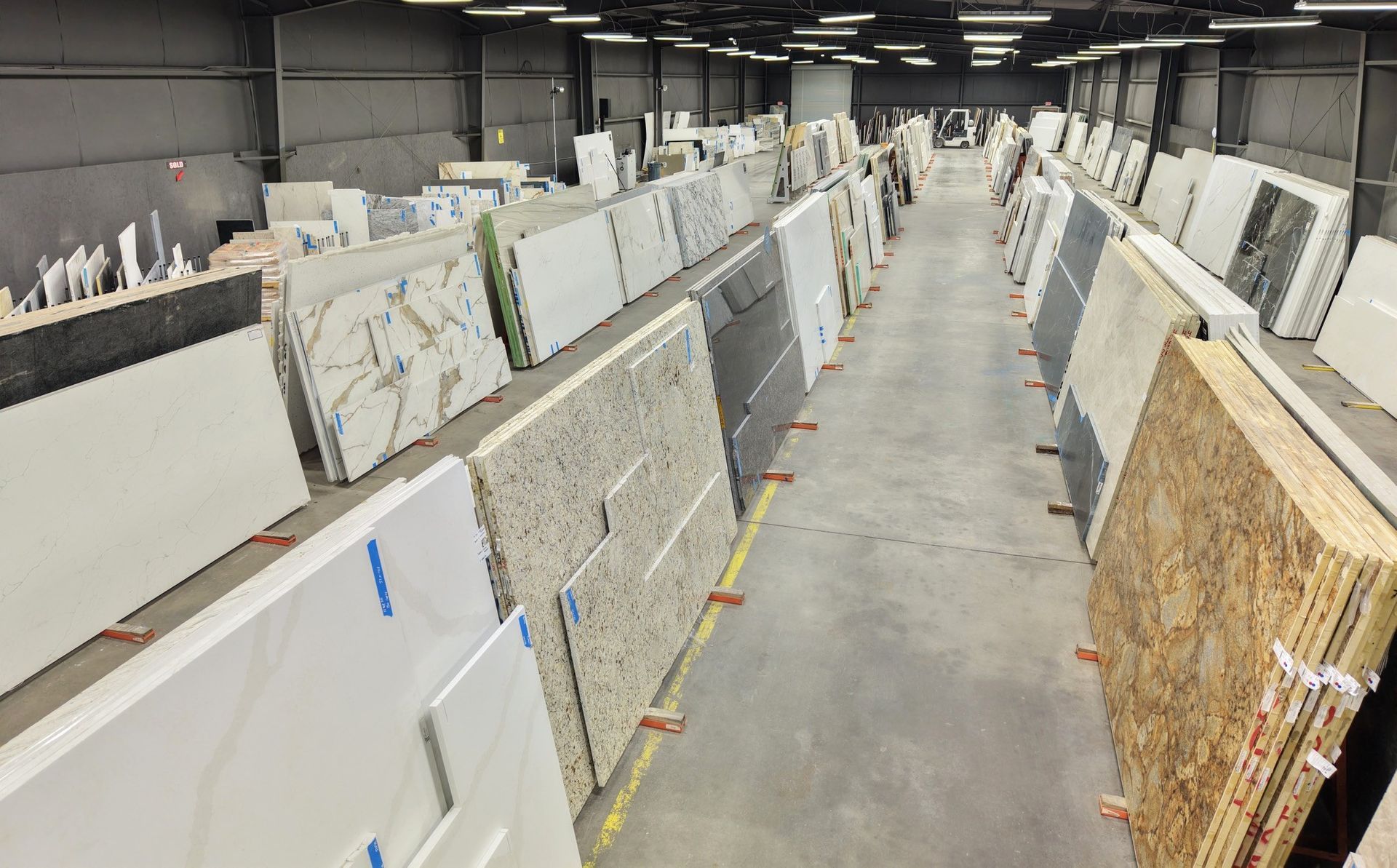 Warehouse displays of stone slabs, showcasing various colors and textures for countertops.