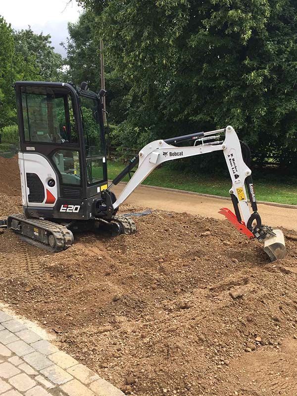 A DHS Plant Hire Bobcat mini excavator is levelling dirt for a new driveway