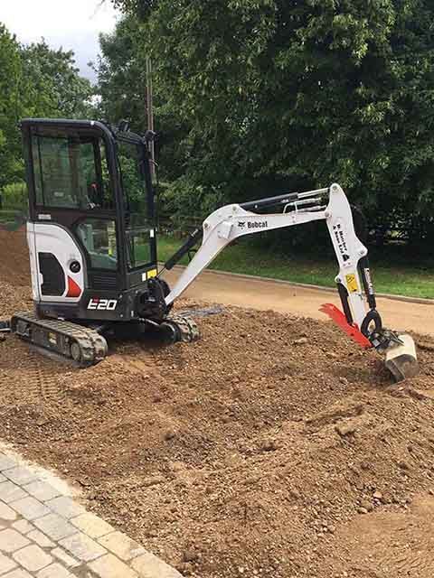 A DHS Plant Hire Bobcat mini excavator is levelling dirt for a new driveway