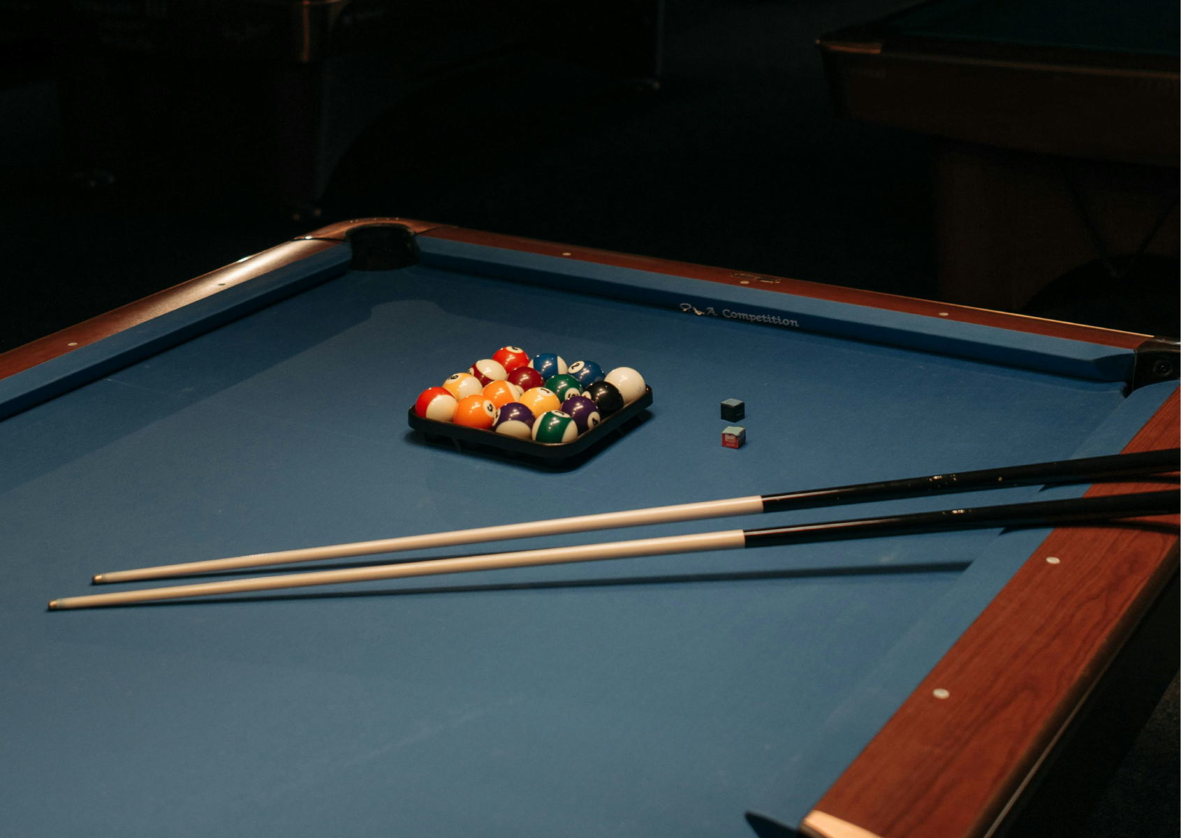 A pool table with balls and cues on it