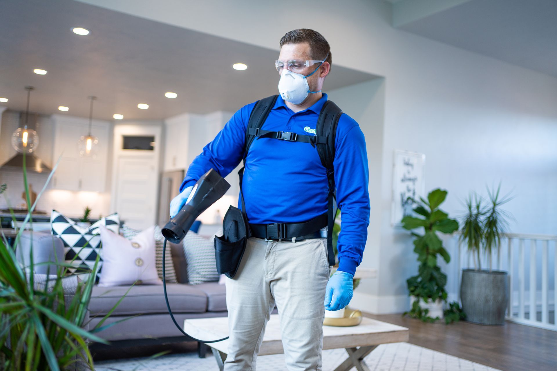 Person spraying carpet with pest control product.