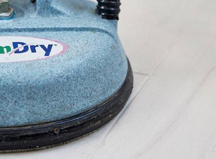 Person wearing gloves connecting gauges to an air conditioning unit.