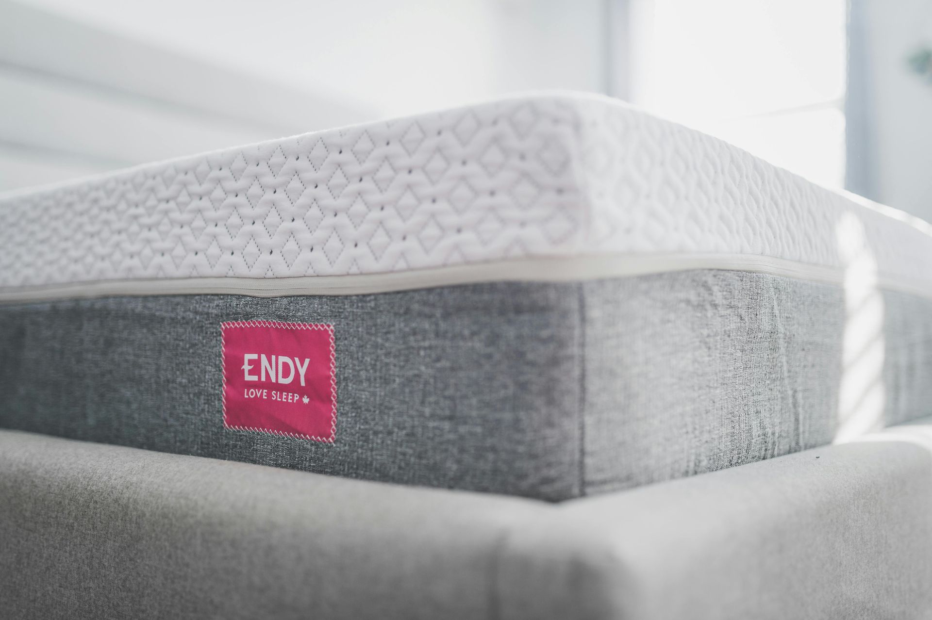 Gray and white Endy mattress, with a pink label.