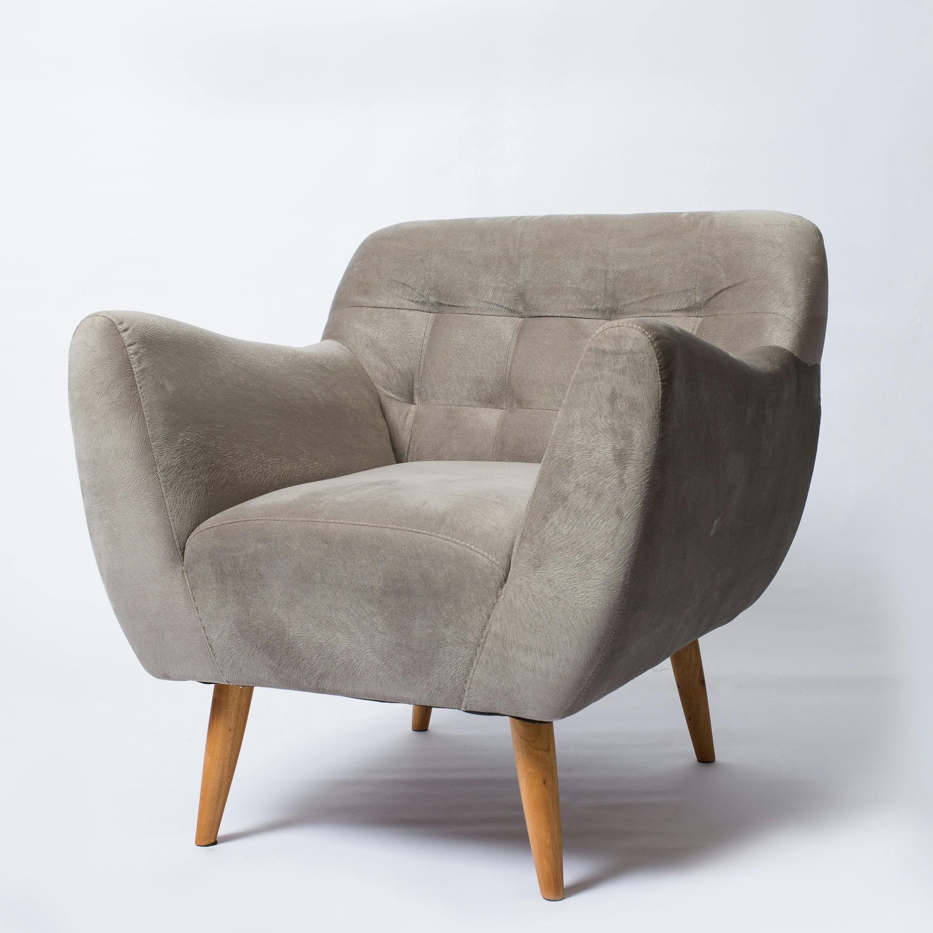 Gray upholstered armchair with wooden legs, against a white background.