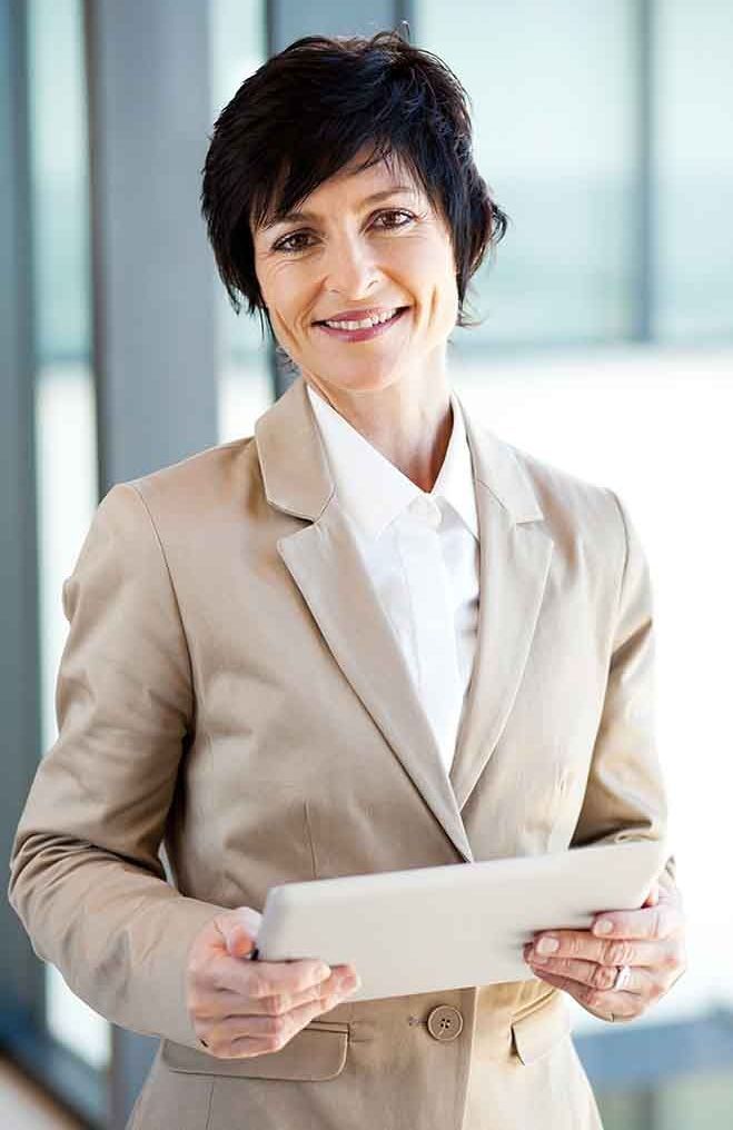 A woman in a suit is holding a tablet computer in her hands.