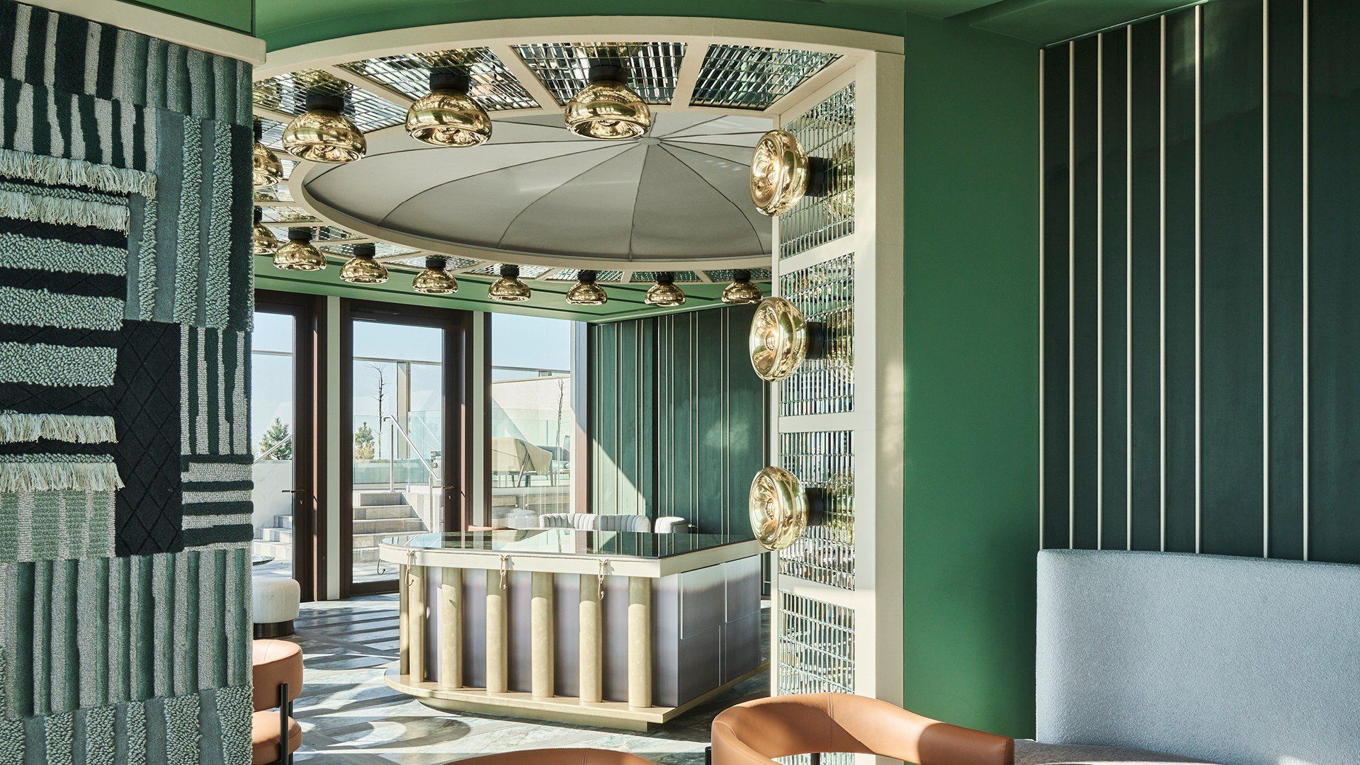 Green and gold room interior with geometric patterns, bar, and unique light fixtures.