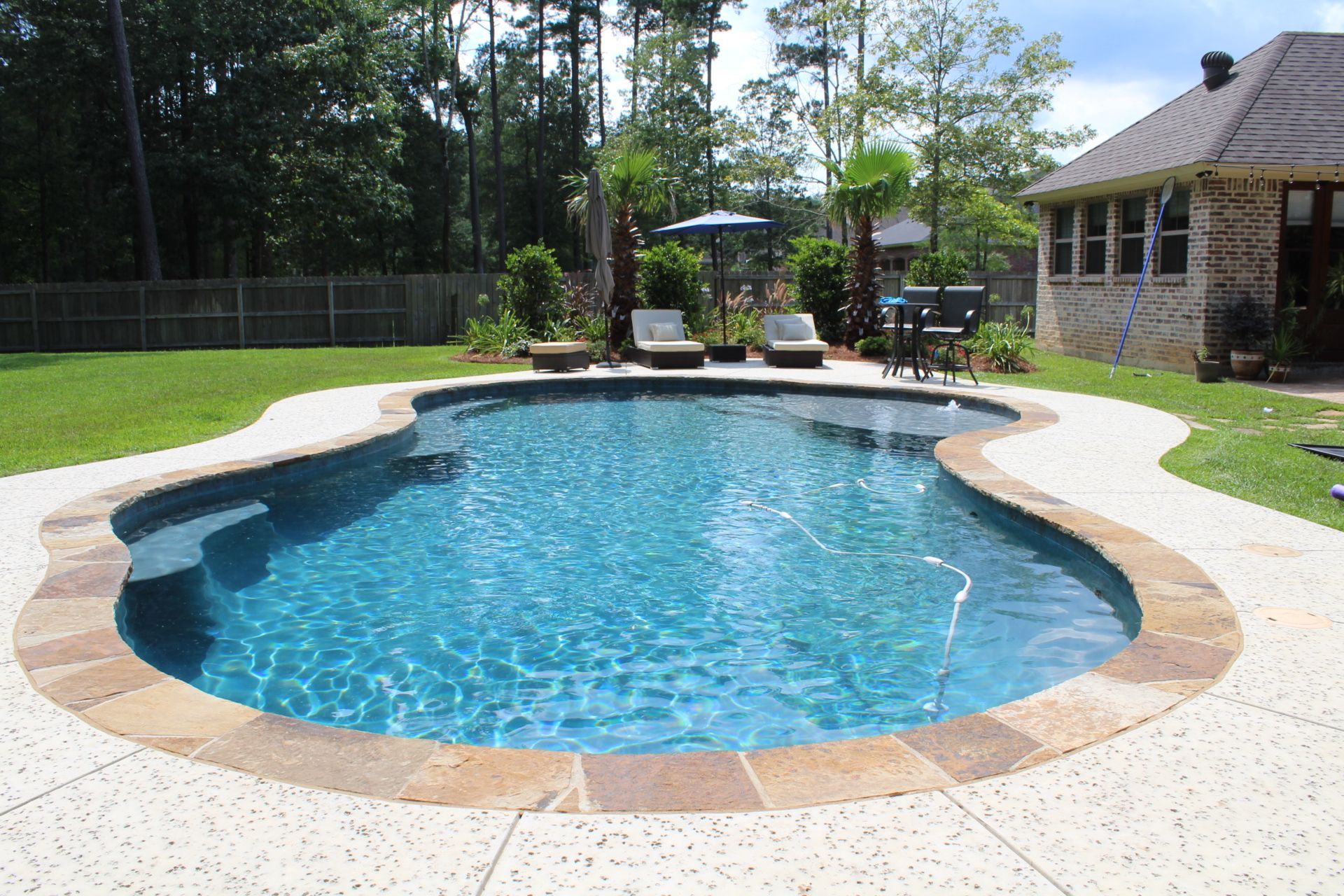 A large swimming pool in the backyard of a house