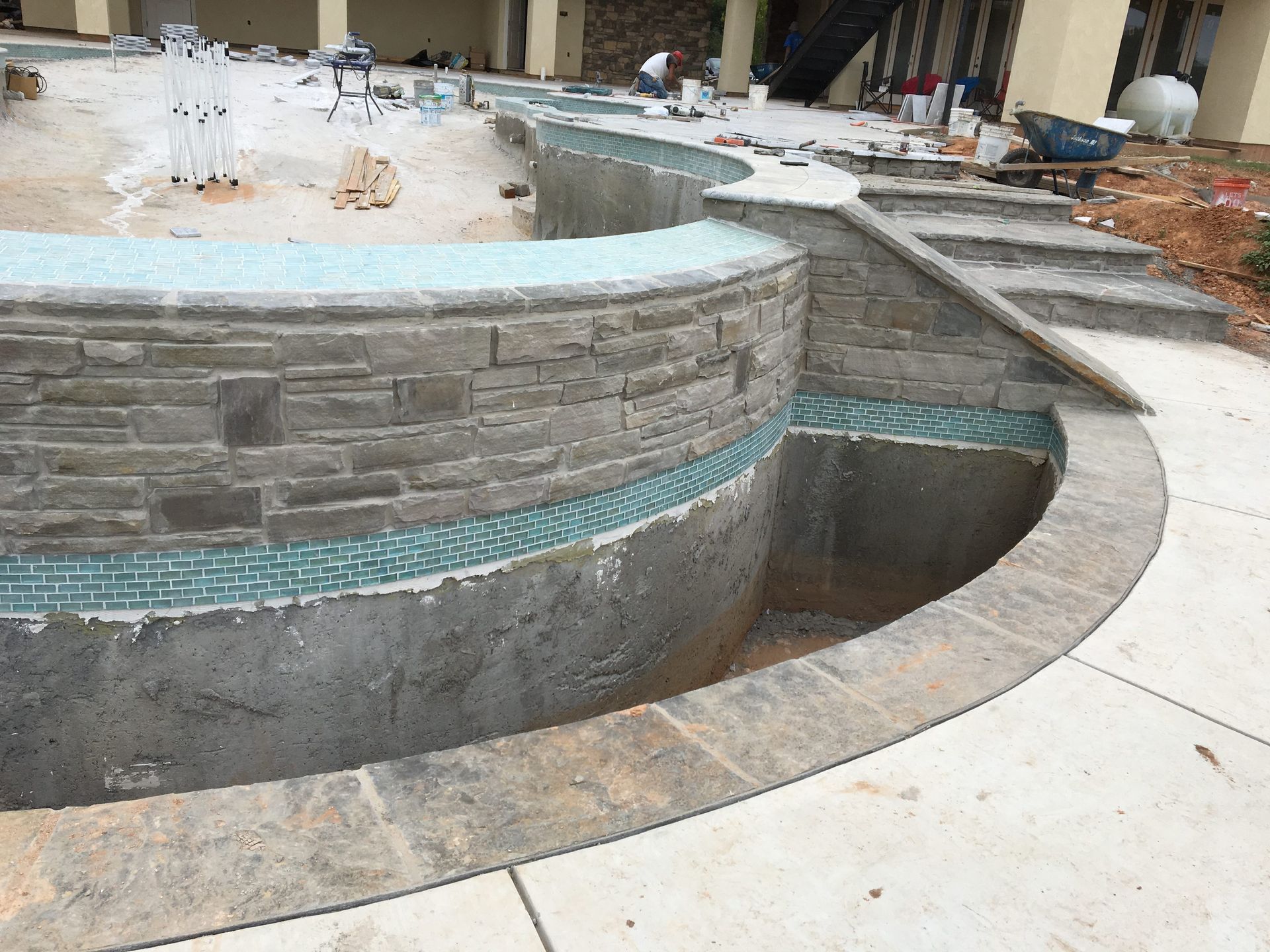 A swimming pool is being built in the backyard of a house
