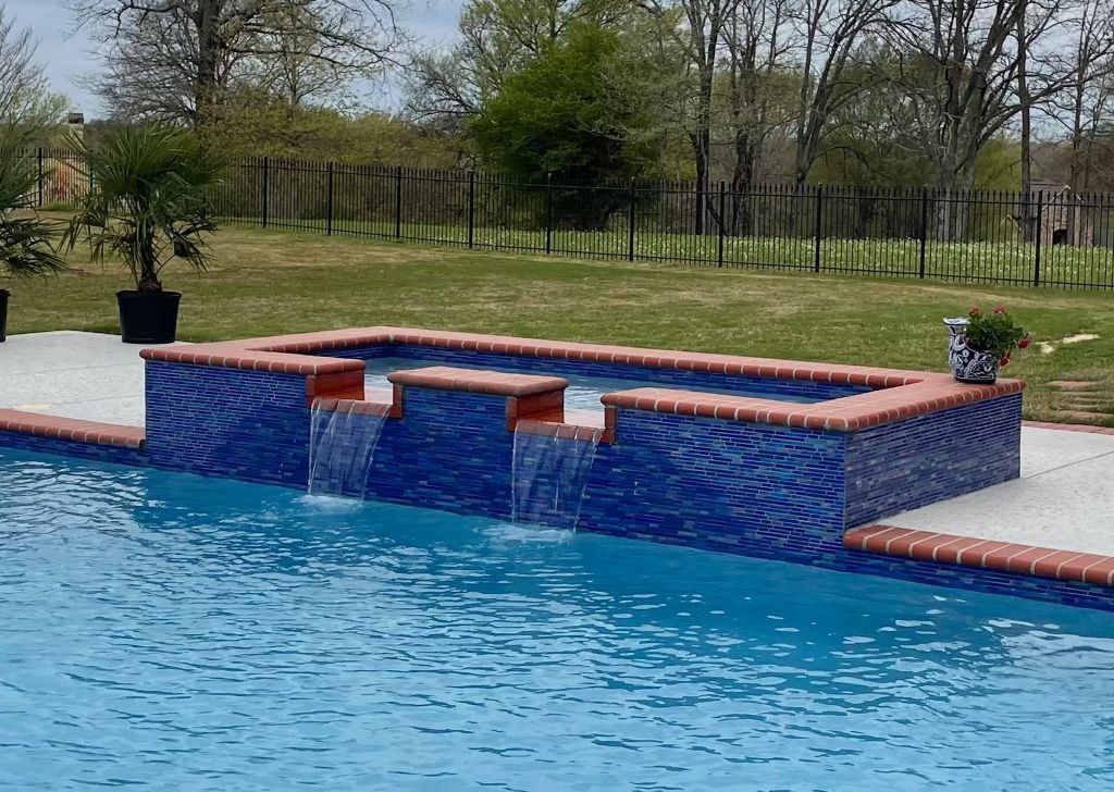 A large swimming pool with a waterfall in the middle