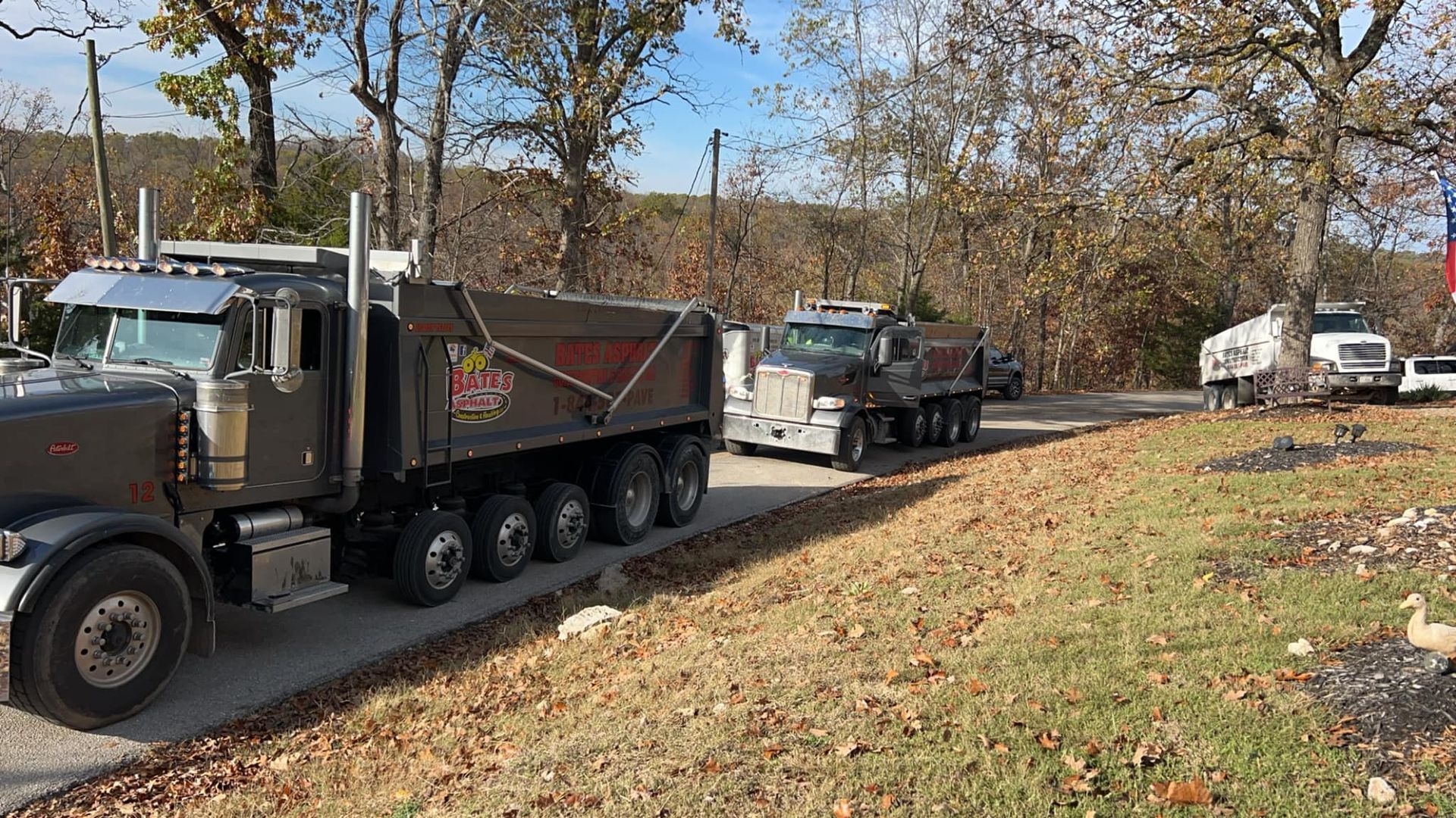A couple of dump trucks are parked on the side of the road.