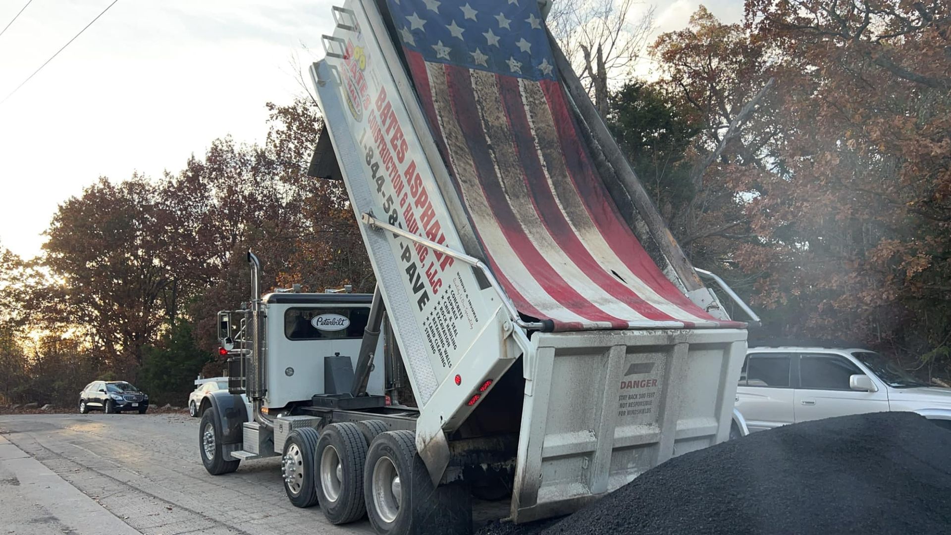 A dump truck with an american flag on it