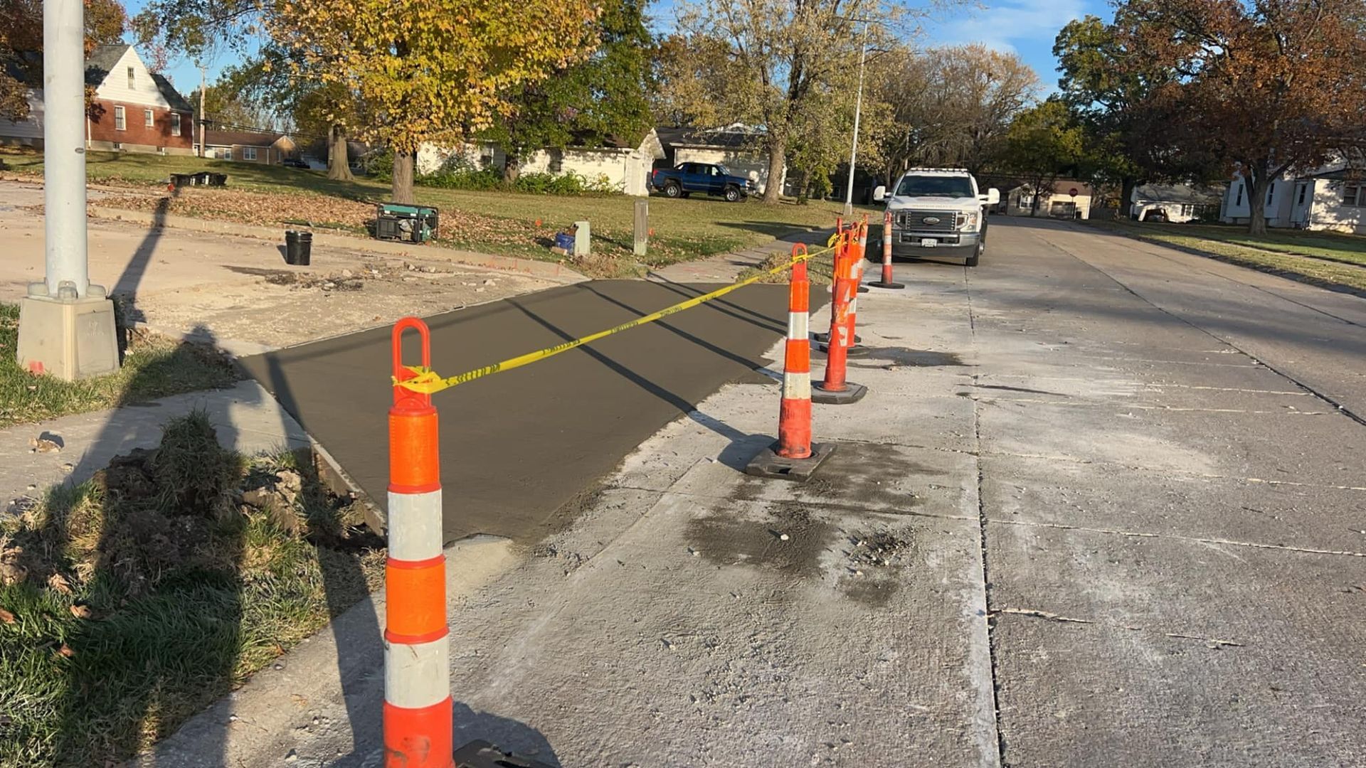 A row of orange and white traffic cones on the side of a road.