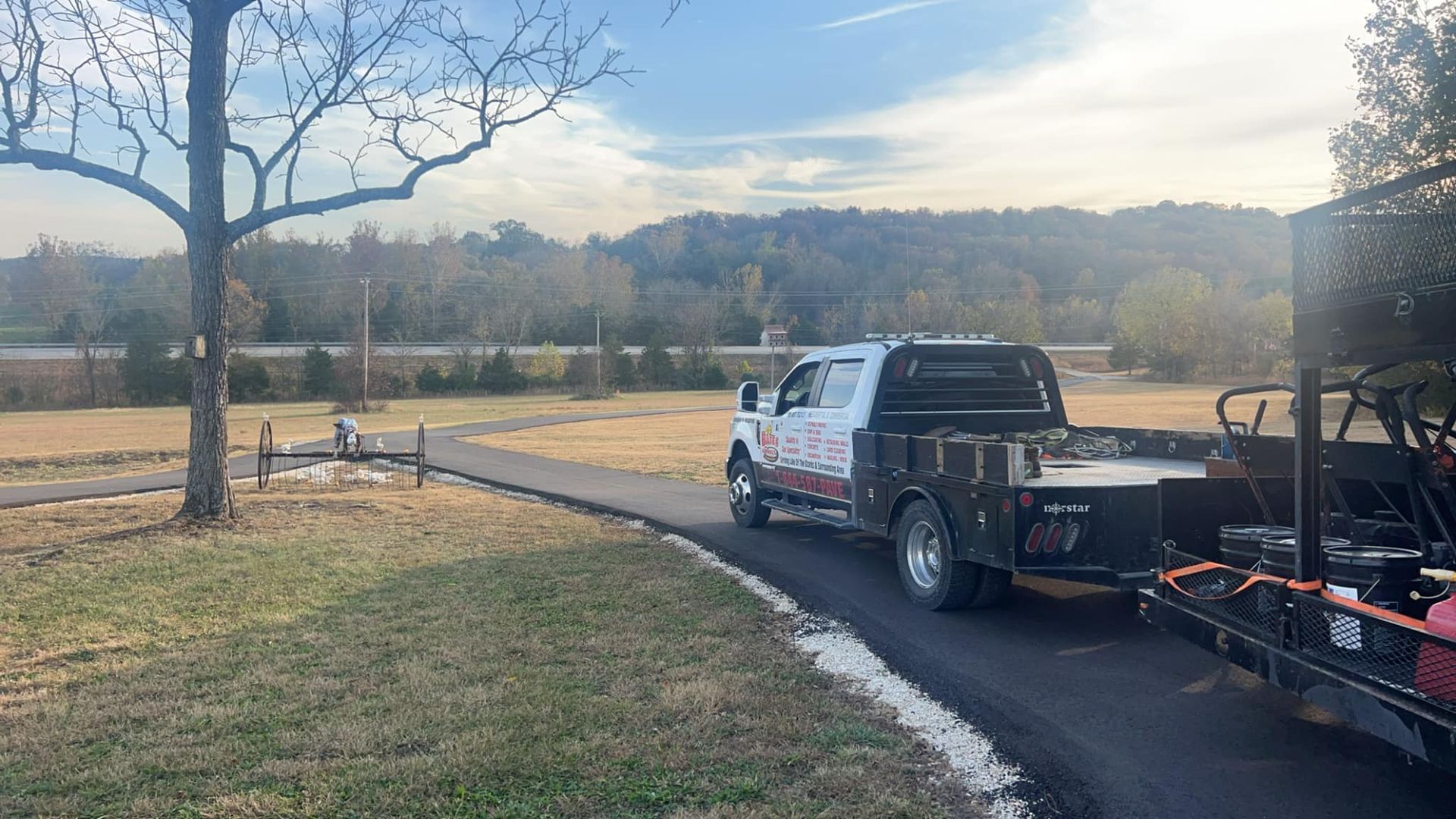 A truck is towing a trailer down a road.
