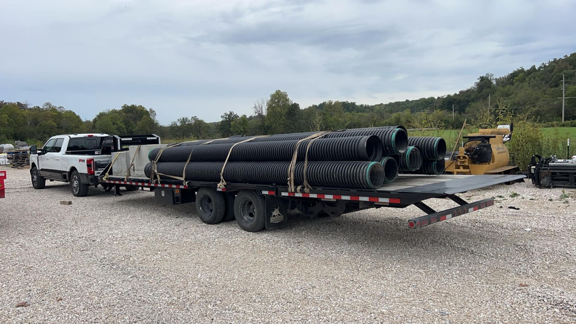 A truck is carrying a trailer full of pipes.