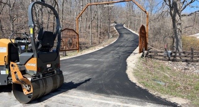 A dump truck is driving down a road next to a white car.