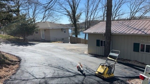 A machine is sitting on the side of a road in front of a house.