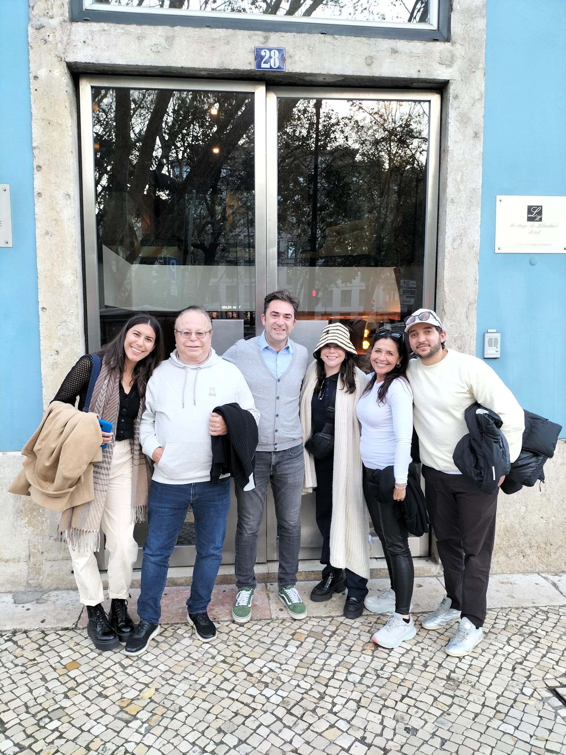 A happy family of travelers with a tour guide leaving the hotel in Lisbon for a private guided day trip to Nazarรฉ, Portugal.