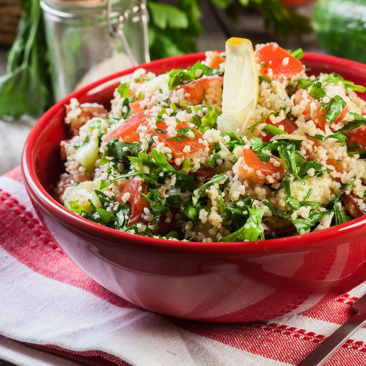 a red bowl filled with rice and vegetables on a table