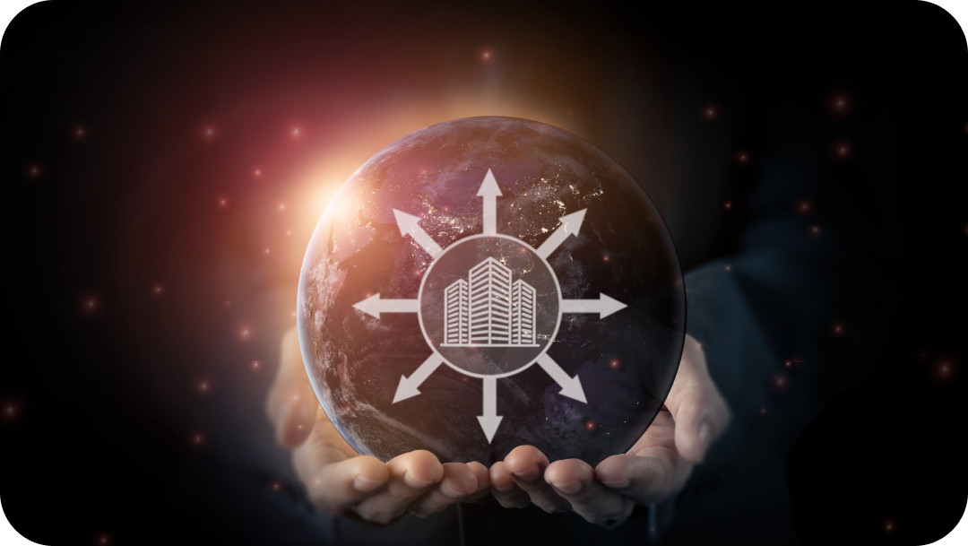 Hands holding a globe with a building icon radiating outward arrows, symbolizing global real estate expansion.