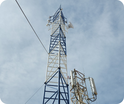 Cell tower with blue and white structure against a cloudy sky.