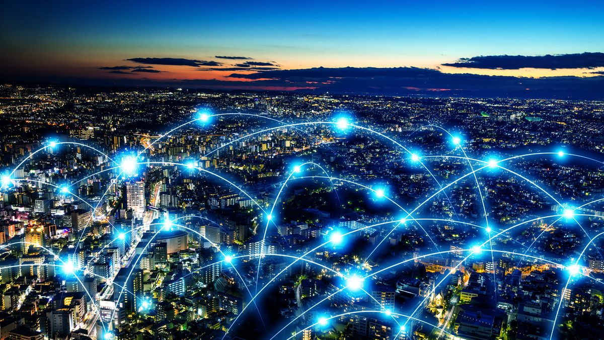 Cityscape at night with glowing blue interconnected lines, symbolizing a network.