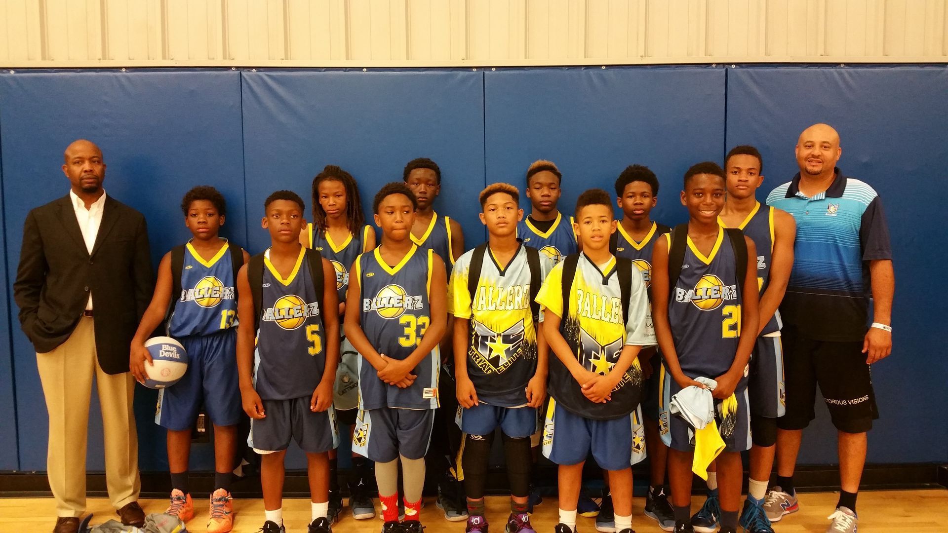 A basketball team poses for a picture with their coaches