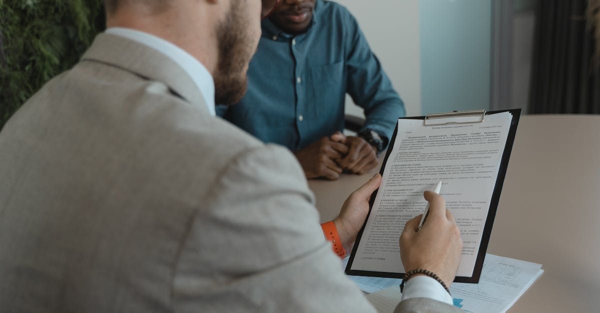 Two men sitting at table, reviewing a document