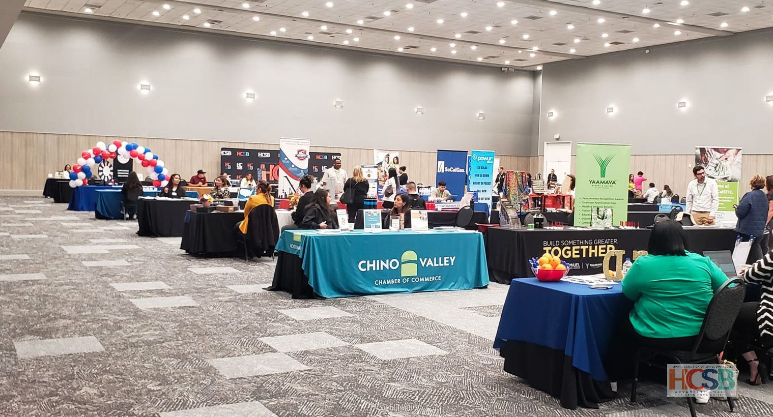 A large room filled with tables and people at a job fair.
