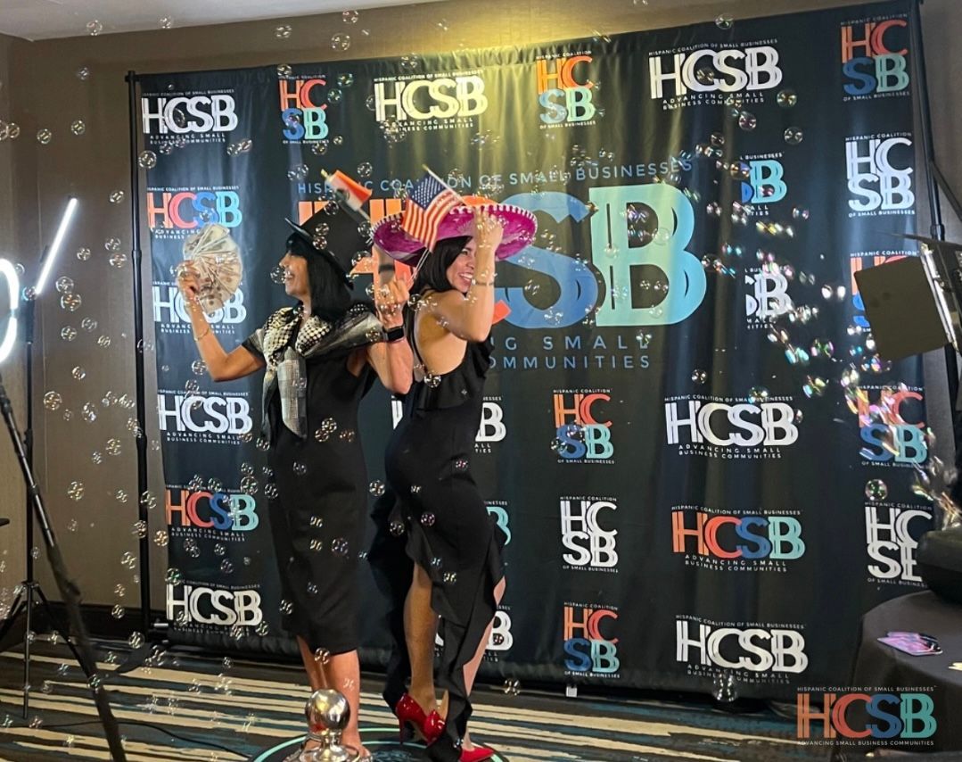 Two women are standing in front of a hcsb banner.