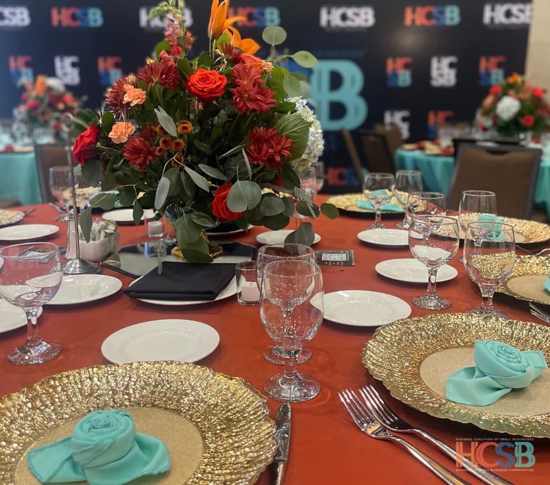 A table set with plates glasses and a vase of flowers