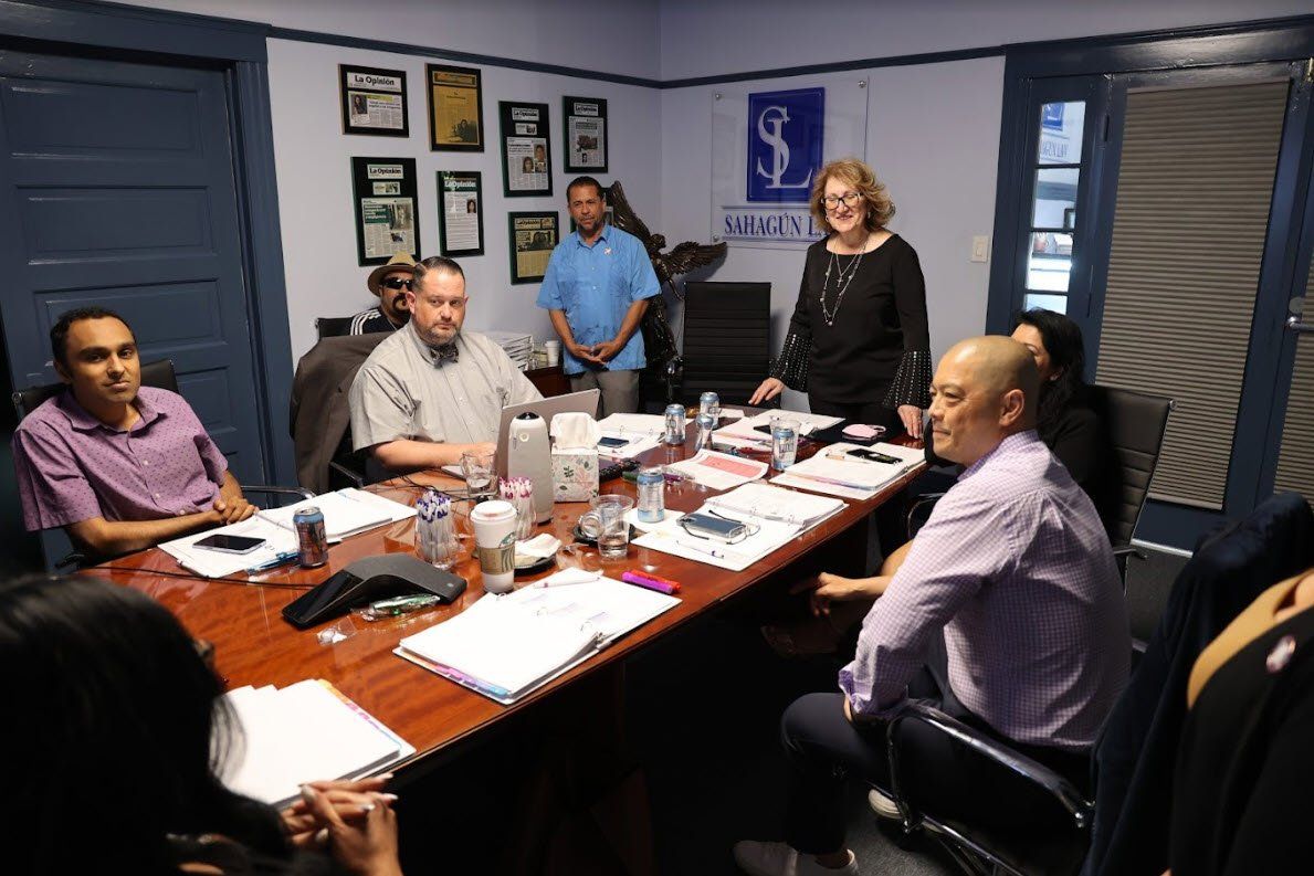 A group of people are sitting around a table in a conference room.