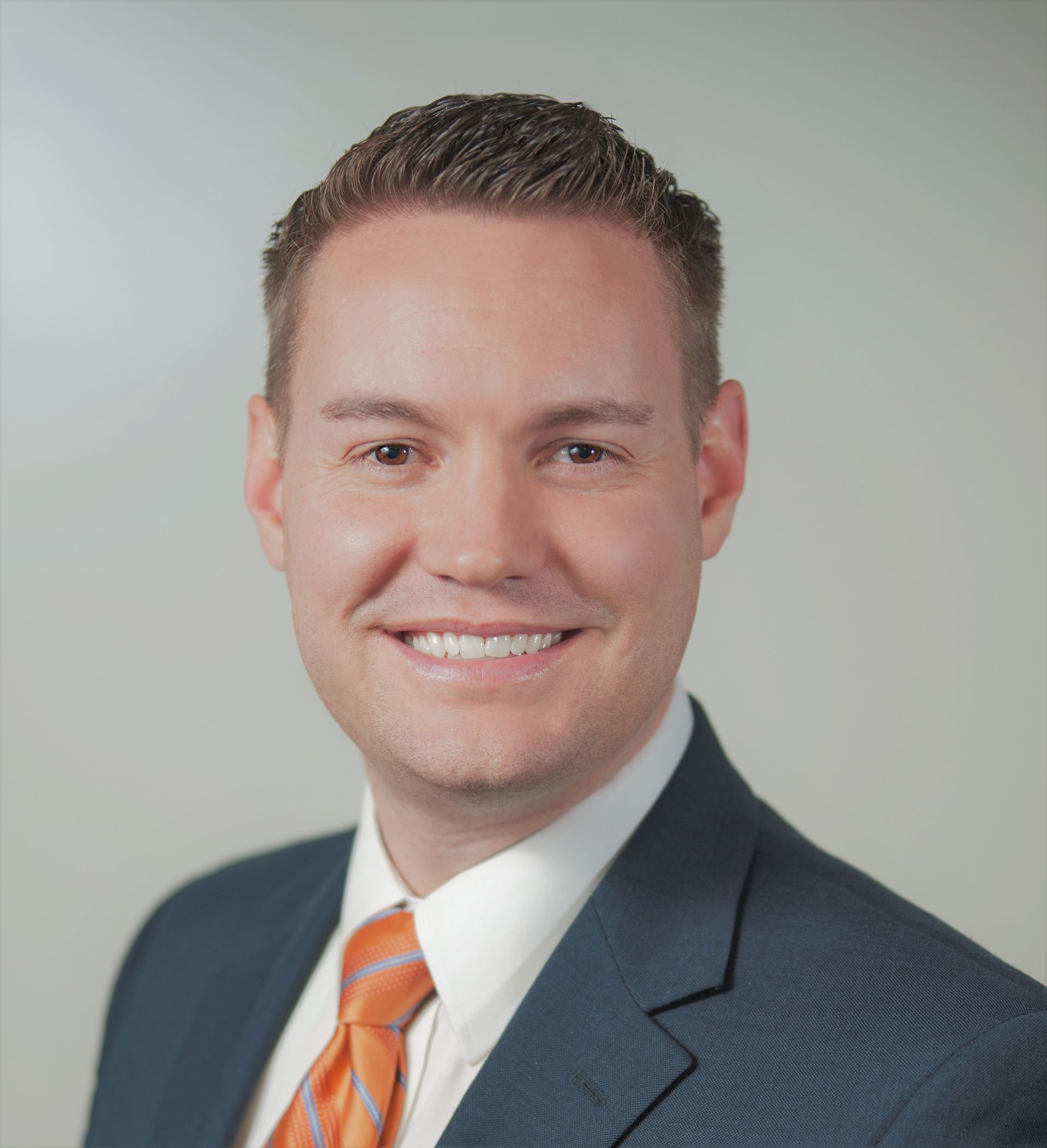 A man in a suit and tie smiles for the camera