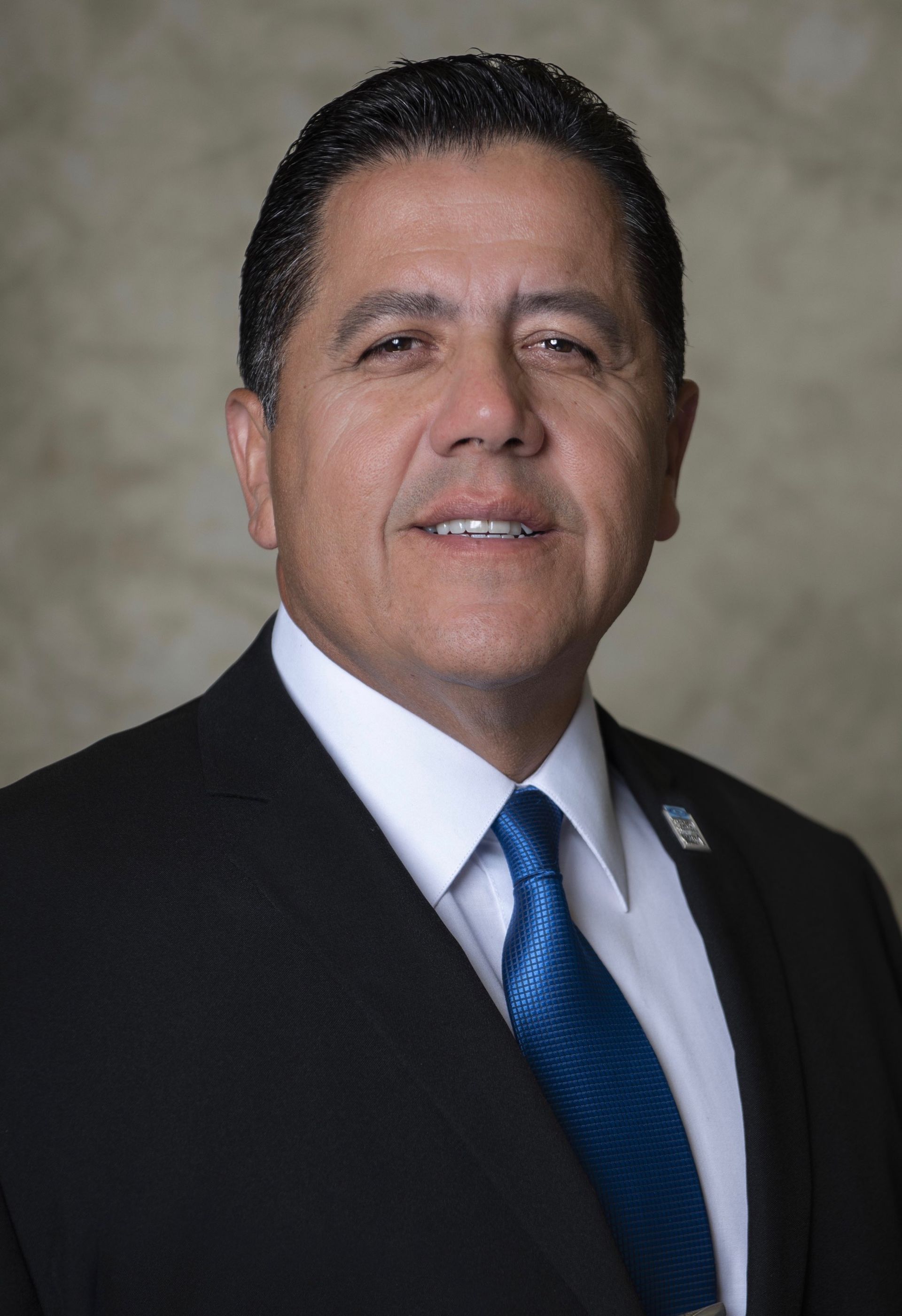 A man in a suit and tie is smiling for the camera